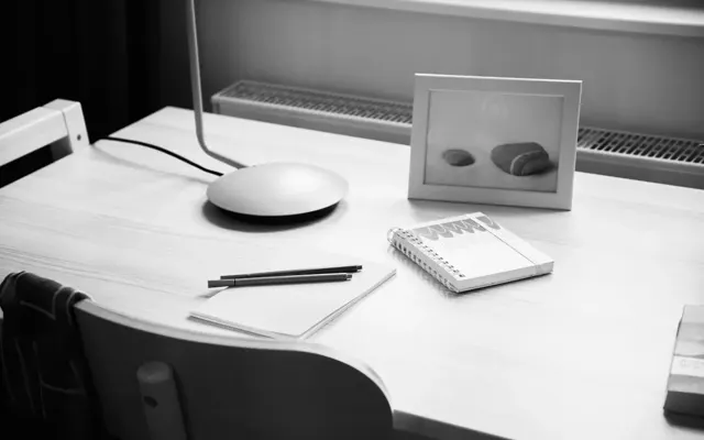 Notebook beside a monitor and framed photograph