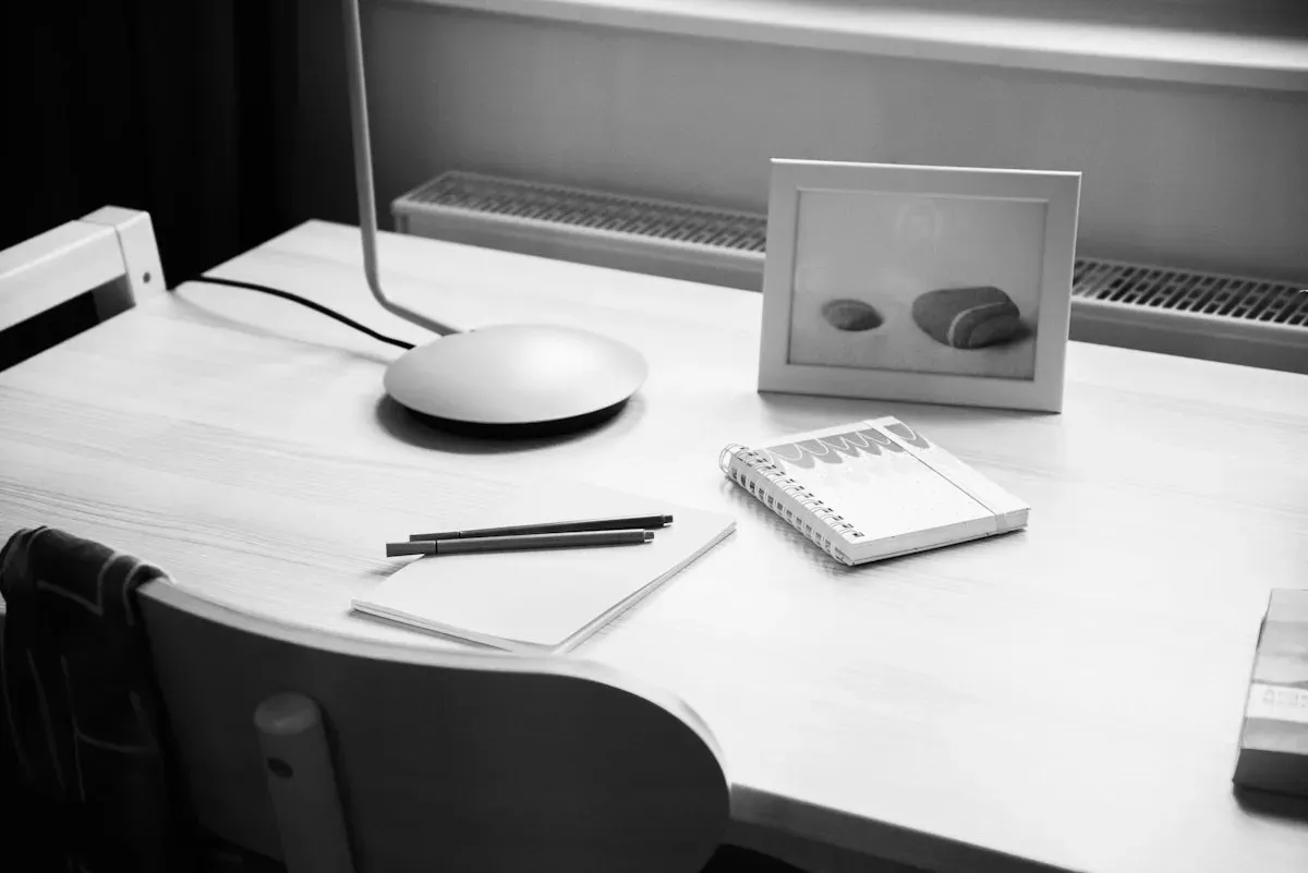 Notebook beside a monitor and framed photograph