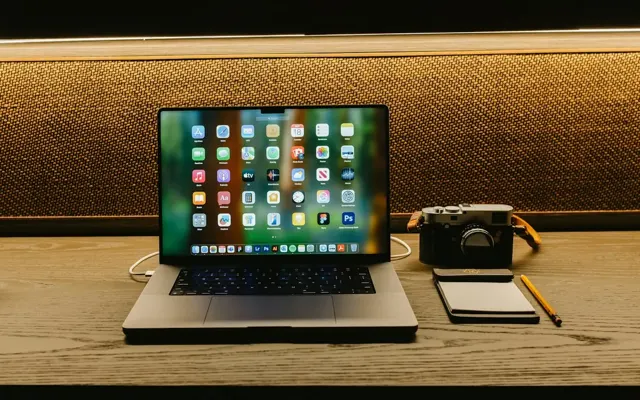 Camera and laptop on a wooden desk