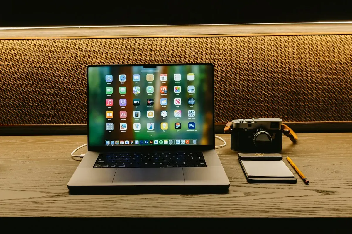 Camera and laptop on a wooden desk